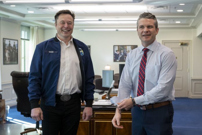 Elon Musk and Pete Hegseth standing next to each other and smiling.